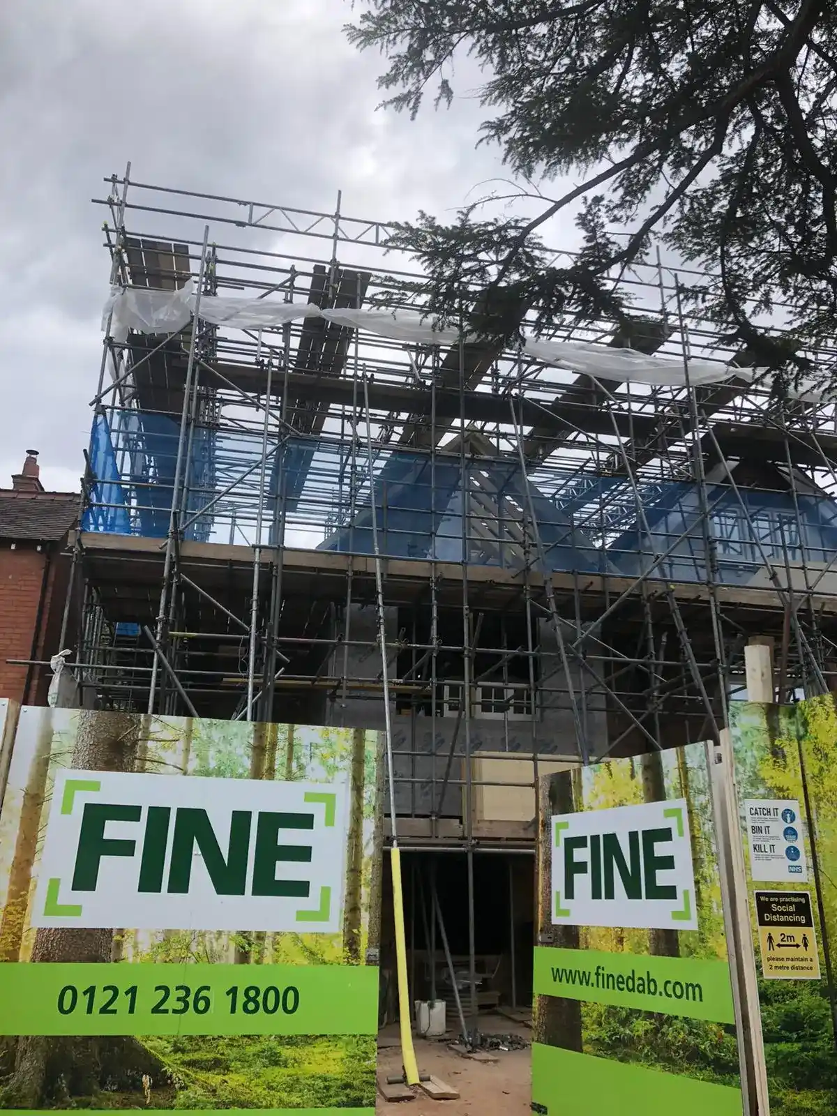 Scaffolding installed around a building with safety netting.