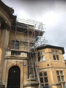 Temporary roof scaffolding installed on a building for weather protection.